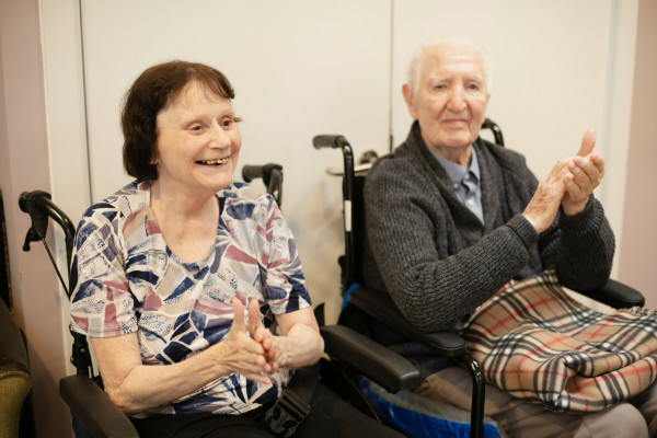 Two elderly people clapping.