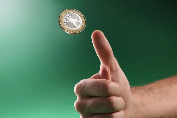Hand flips a coin.