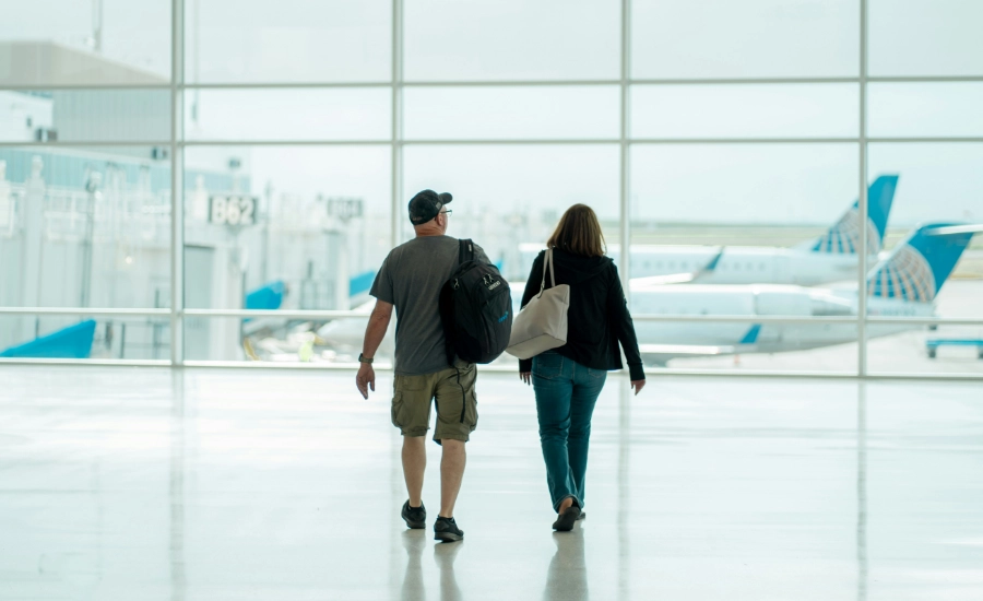 A man and a woman walking through an airport.